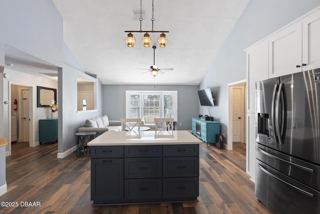 kitchen with white cabinetry, stainless steel fridge, dark hardwood / wood-style floors, and vaulted ceiling