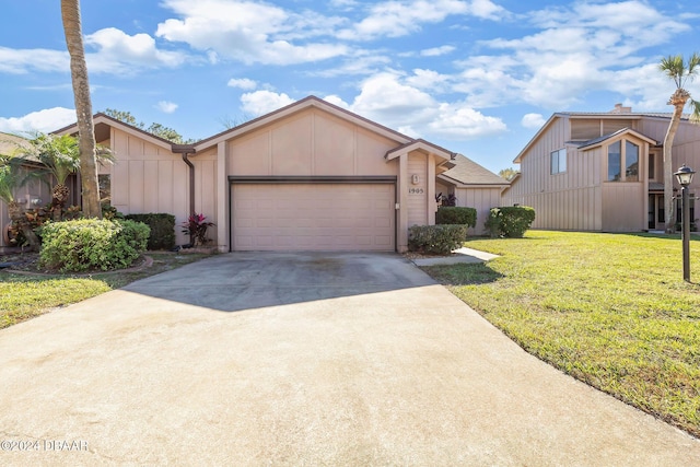 view of front facade with board and batten siding, a garage, a front yard, and driveway