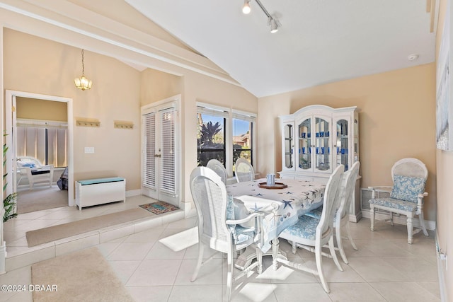 tiled dining room featuring a chandelier, french doors, baseboards, and lofted ceiling