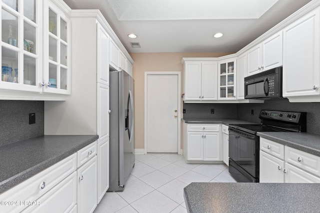 kitchen with light tile patterned floors, glass insert cabinets, dark countertops, black appliances, and white cabinetry