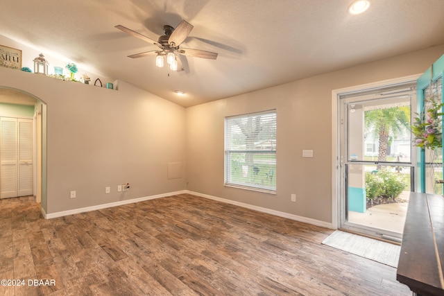 spare room featuring a wealth of natural light, wood-type flooring, and vaulted ceiling