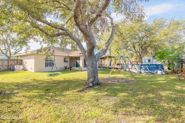 view of yard featuring a fenced in pool and central AC