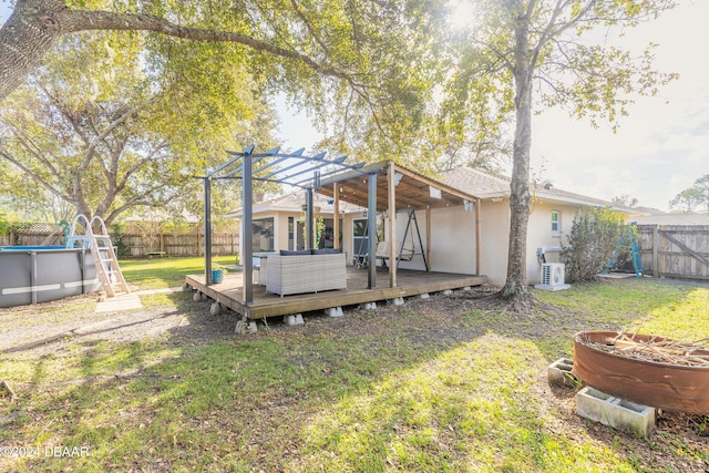 rear view of house with a yard, a pergola, an outdoor living space, and a pool side deck