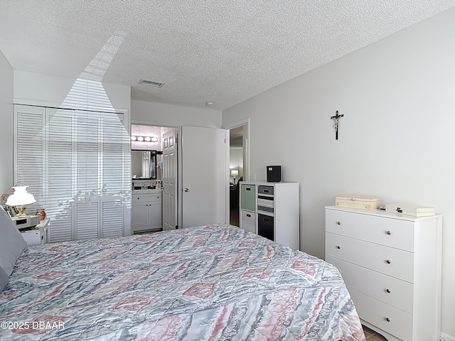 420 Banana Cay Dr Unit A, South Daytona, FL 32119 - bedroom with visible vents, a textured ceiling, and ensuite bathroom