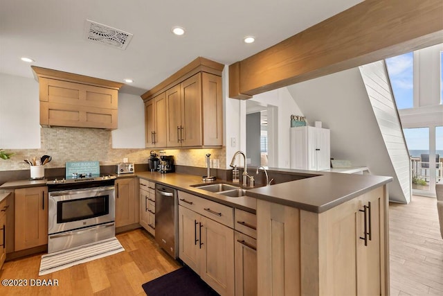kitchen featuring dark countertops, appliances with stainless steel finishes, visible vents, and a sink