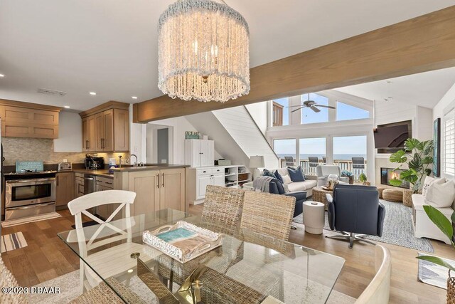 dining space featuring wood finished floors, ceiling fan with notable chandelier, vaulted ceiling with beams, visible vents, and recessed lighting