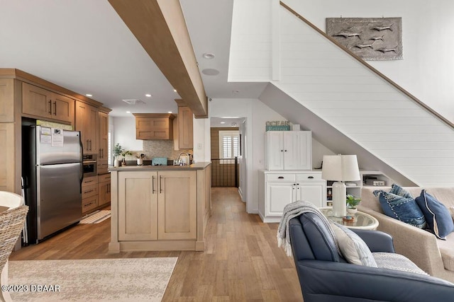 kitchen featuring light wood-style flooring, open floor plan, recessed lighting, and appliances with stainless steel finishes