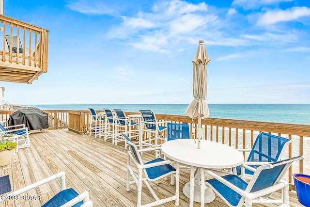 wooden terrace with outdoor dining area, a water view, and grilling area