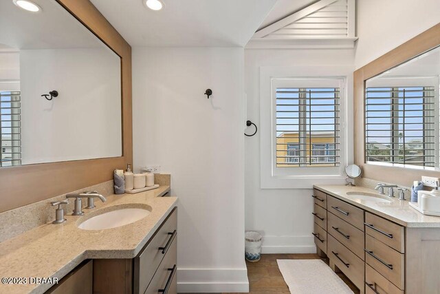full bathroom with a sink, two vanities, baseboards, and recessed lighting