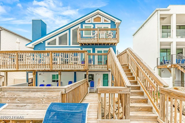 back of property featuring a balcony, stairway, and a wooden deck