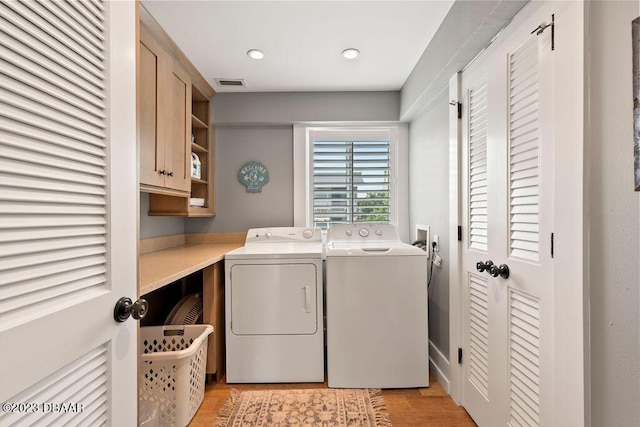 laundry area featuring light wood-style flooring, cabinet space, separate washer and dryer, visible vents, and recessed lighting