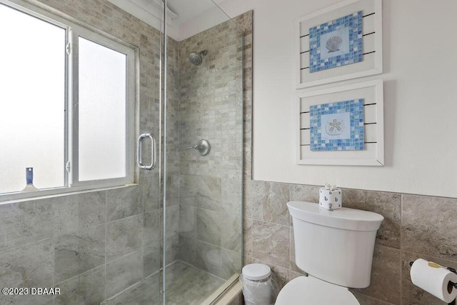 full bathroom featuring tile walls, toilet, and a stall shower
