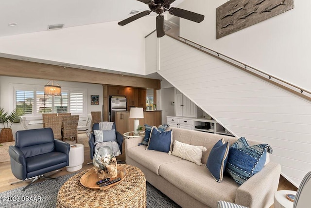 living area featuring high vaulted ceiling, light wood-style flooring, a ceiling fan, and visible vents