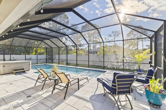 view of pool with a hot tub, glass enclosure, and a patio area