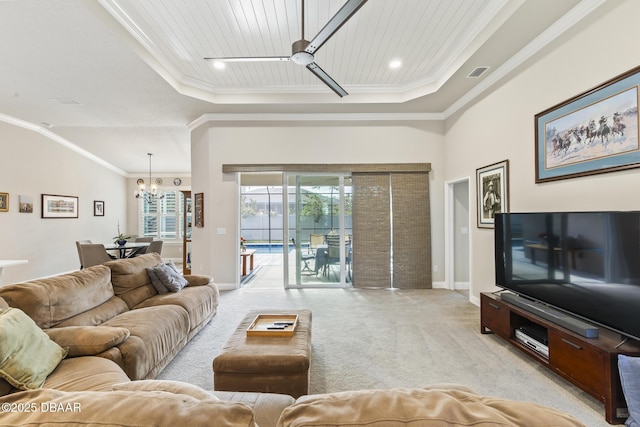 carpeted living room featuring ornamental molding, ceiling fan with notable chandelier, wooden ceiling, and a tray ceiling