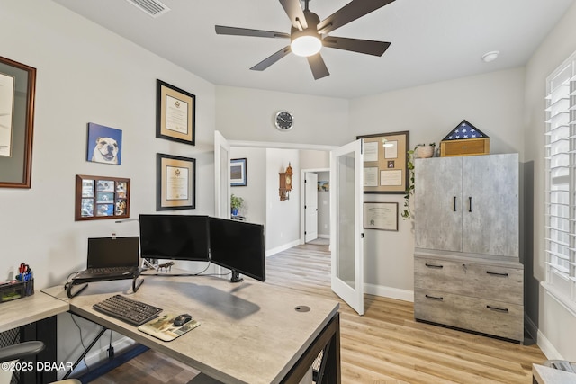 office with french doors, ceiling fan, and light wood-type flooring