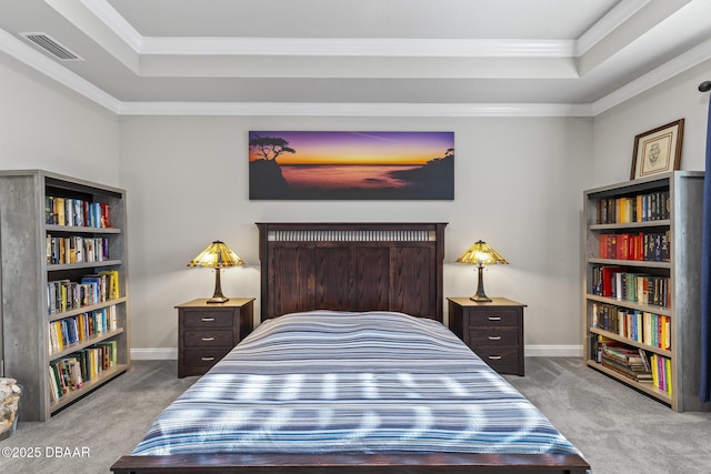 carpeted bedroom with crown molding and a tray ceiling