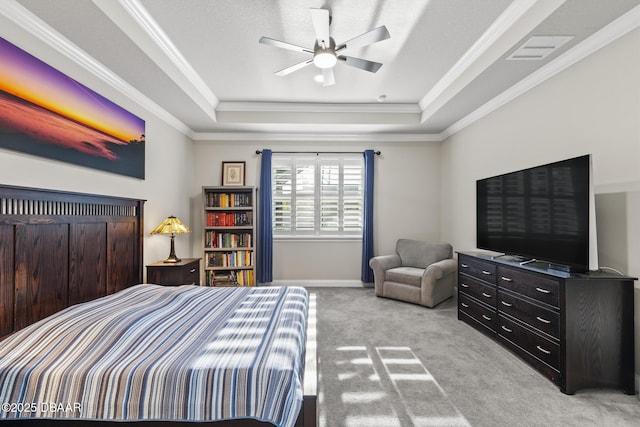 bedroom featuring ceiling fan, light colored carpet, ornamental molding, and a tray ceiling