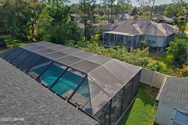 view of swimming pool featuring glass enclosure