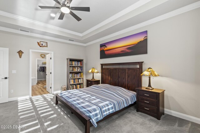 carpeted bedroom featuring a tray ceiling, ornamental molding, and ceiling fan