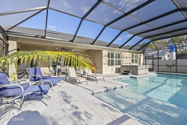 view of swimming pool with ceiling fan, a hot tub, a patio area, and a lanai