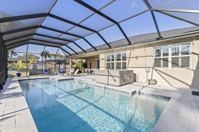 view of swimming pool with a lanai, a patio area, and a hot tub