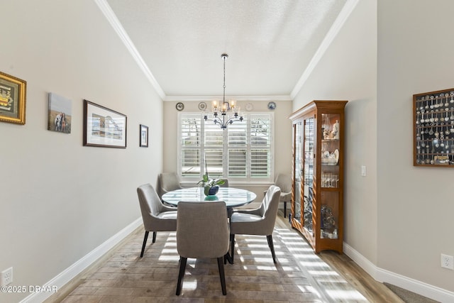 dining area featuring crown molding, a chandelier, and hardwood / wood-style flooring