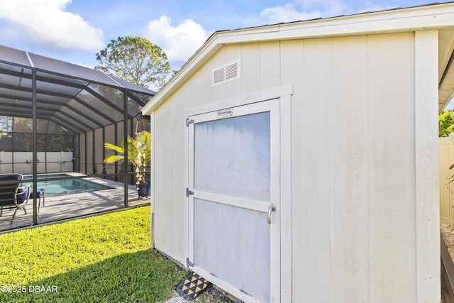 view of outbuilding with a fenced in pool and a yard