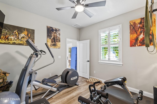 exercise area with ceiling fan and light wood-type flooring