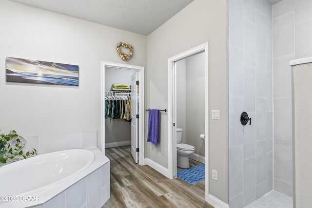 bathroom featuring wood-type flooring, separate shower and tub, a textured ceiling, and toilet