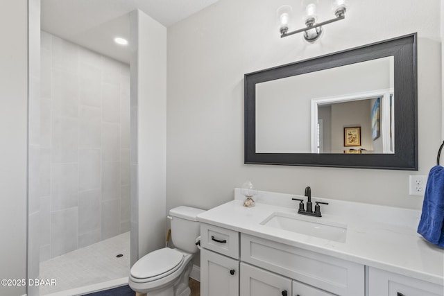 bathroom with vanity, toilet, and a tile shower