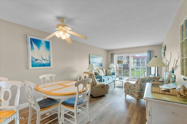 dining room featuring a textured ceiling, ceiling fan, and light hardwood / wood-style flooring