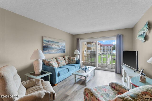 living room with a textured ceiling and light hardwood / wood-style floors