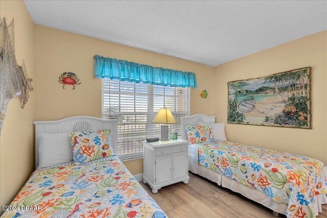 bedroom with a textured ceiling and light hardwood / wood-style flooring