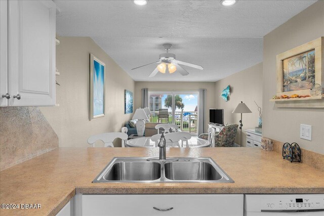 kitchen with dishwasher, a textured ceiling, sink, ceiling fan, and white cabinetry