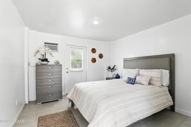 tiled bedroom with a wall mounted air conditioner and baseboards