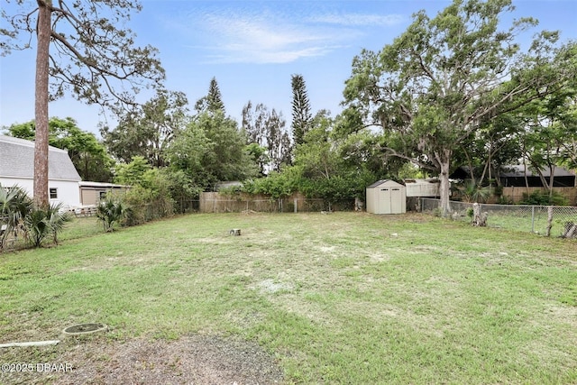 view of yard featuring a fenced backyard, an outbuilding, and a storage shed