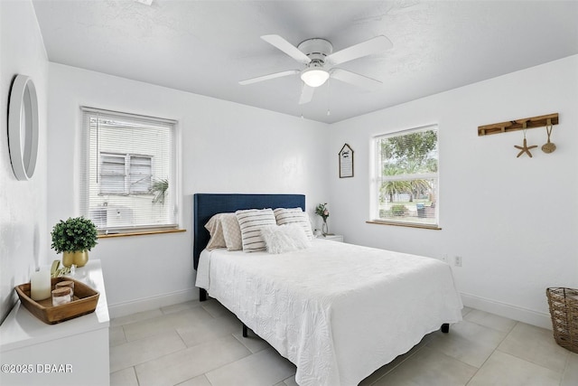 bedroom with baseboards, a ceiling fan, and light tile patterned floors