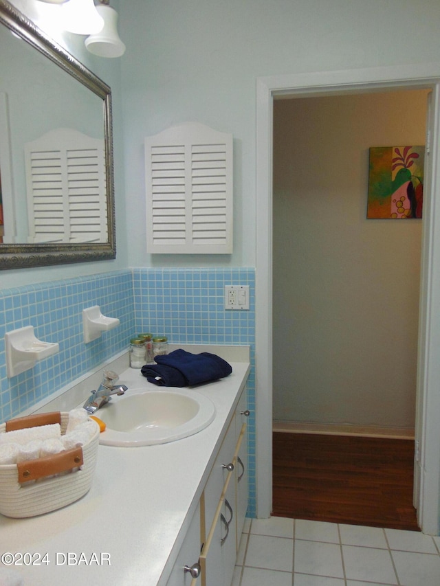 bathroom featuring tile patterned flooring, vanity, and tile walls