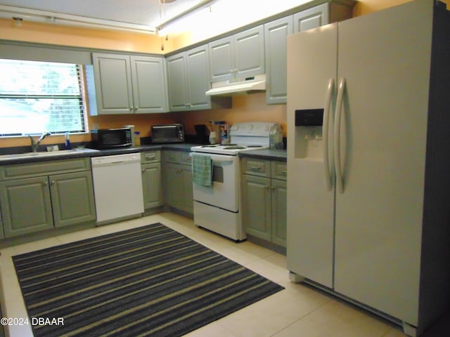 kitchen with light tile patterned flooring, white appliances, and sink