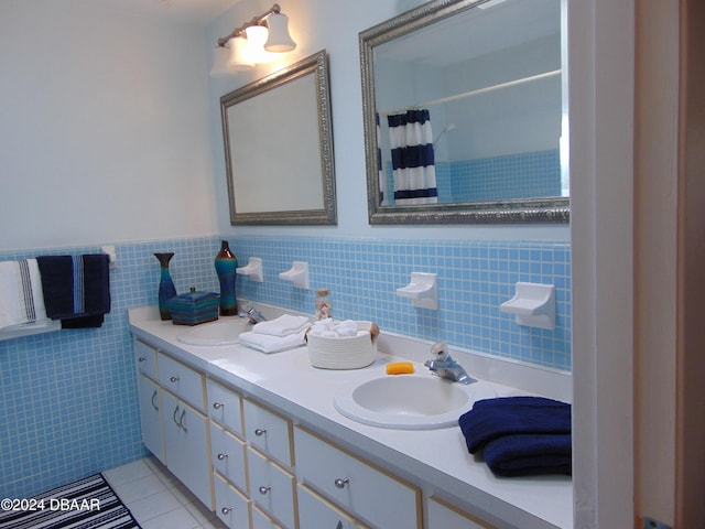 bathroom with vanity, tile patterned floors, tile walls, and curtained shower