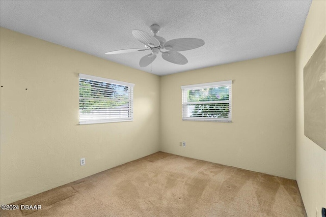 carpeted empty room featuring a textured ceiling and ceiling fan