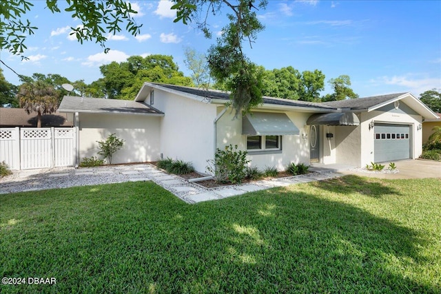 ranch-style home featuring a garage and a front lawn