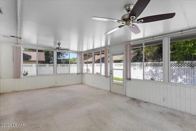 unfurnished sunroom with ceiling fan