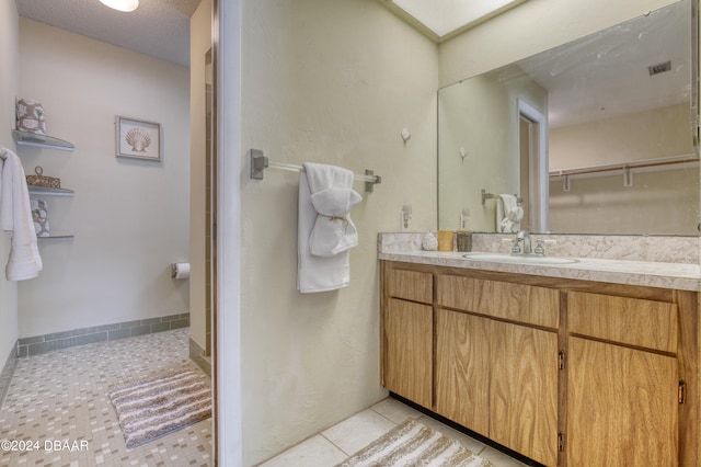 bathroom with vanity, a textured ceiling, and tile patterned floors