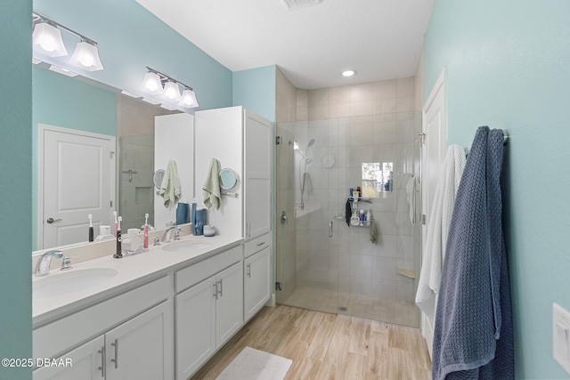 bathroom with vanity, wood-type flooring, and a shower with door