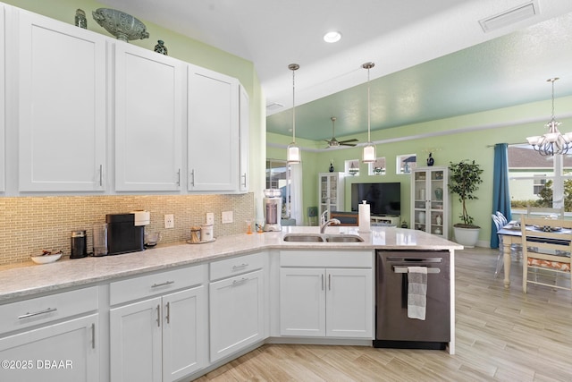 kitchen with sink, white cabinets, stainless steel dishwasher, and decorative light fixtures