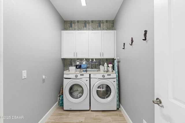 washroom featuring cabinets, separate washer and dryer, and light wood-type flooring