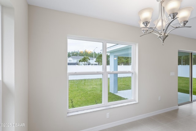 interior space featuring light tile patterned floors, a healthy amount of sunlight, baseboards, and an inviting chandelier