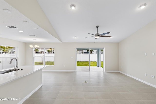 unfurnished living room featuring visible vents, baseboards, light tile patterned floors, ceiling fan with notable chandelier, and a sink